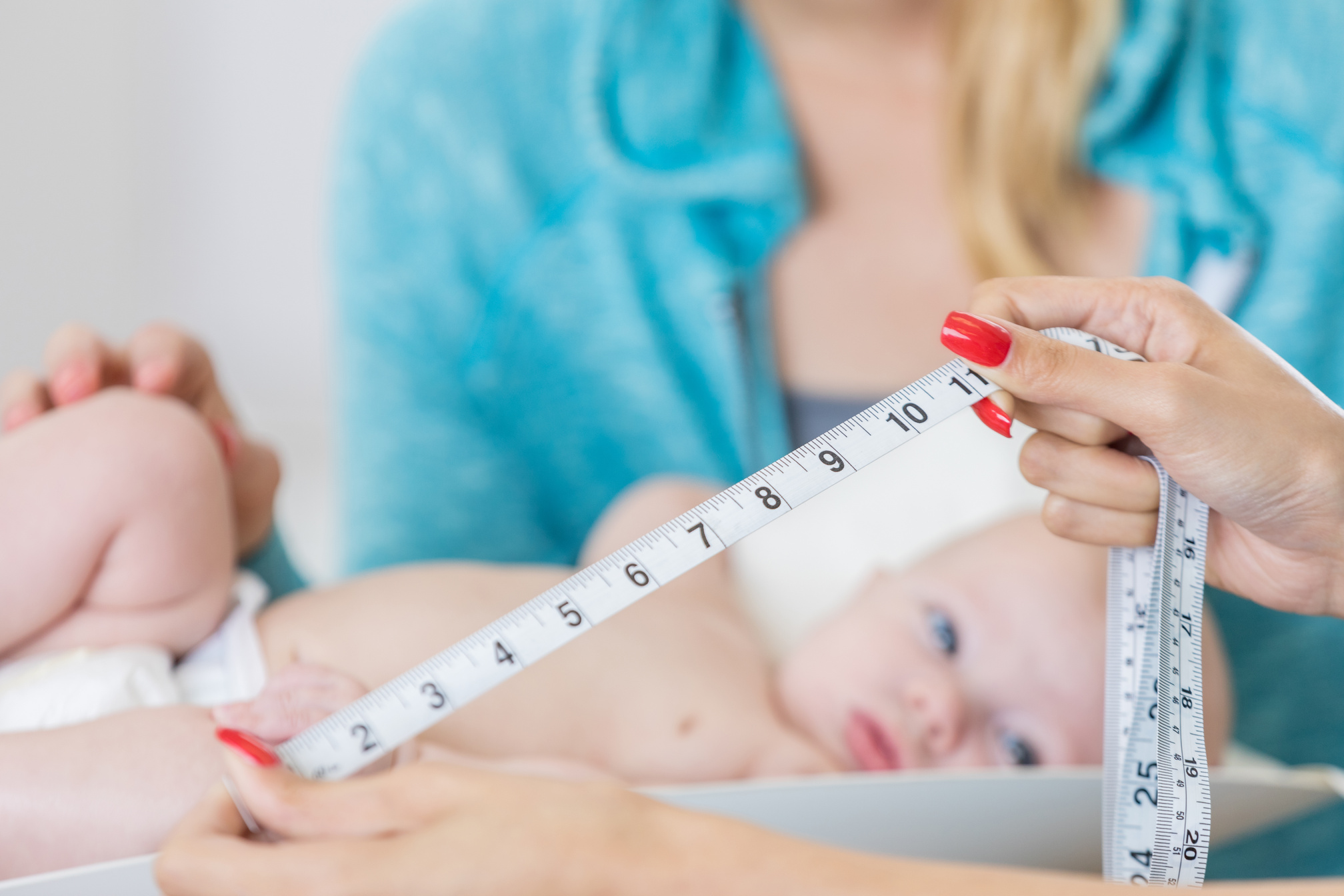 Nurse measures baby's head circumference